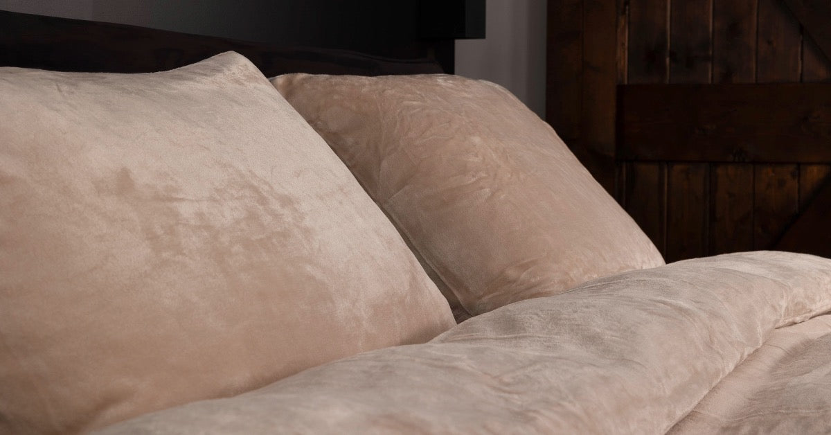 Afbeelding van een bed met een luxe, mooi opgemaakt dekbedovertrek van fluweel (velvet) in een zachte amandelkleur. Het bed straalt warmte en comfort uit, met een glanzende en elegante uitstraling van het velvet materiaal.
foto: dekbedovertrek 240x220 amandel