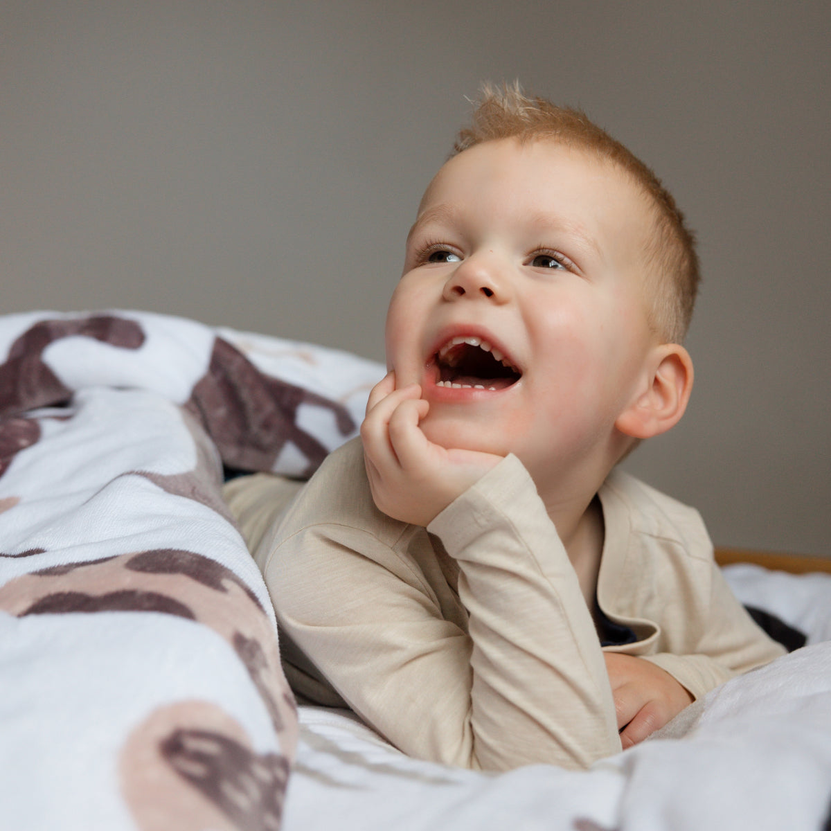 Een peuterbed opgemaakt met een zacht velvet dekbedovertrek, bedrukt met schattige hondjes in verschillende kleuren en poses. Het comfortabele materiaal zorgt voor een knusse en vrolijke sfeer. foto: hondjes dekbedovertrek peuter.