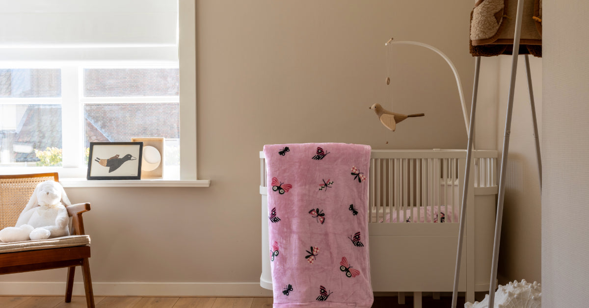 Close-up van een babykamer met een velvet dekbedovertrek in zachte kleuren, versierd met een vlinderpatroon. Het dekbedovertrek hangt elegant over een schattig ledikantje, waardoor een warme en uitnodigende sfeer ontstaat. De textuur van het velvet en het delicate ontwerp van de vlinders zijn goed zichtbaar, wat de aandacht vestigt op de aandacht voor detail in de inrichting van de kamer.
foto: ledikant dekbedovertrek vlinder kinderkamer