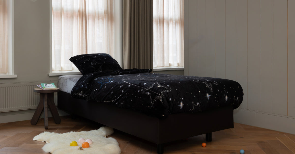 Een prachtig velvet dekbedovertrek met een space-print, dat op een opgemaakt bed ligt in een lichte, gezellige kamer. De kamer is uitnodigend ingericht met veel natuurlijk licht dat door de ramen valt. Het dekbedovertrek is heerlijk zacht en voegt een speelse, moderne uitstraling toe aan de ruimte.
foto: space dekbedovertrek eenpersoons kinderkamer