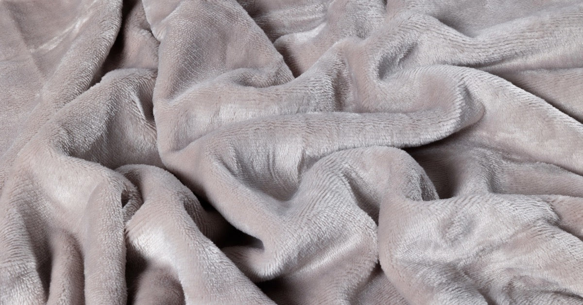 Close-up van een taupe velvet dekbedovertrek, met een zachte, luxueuze textuur. De stof heeft een subtiele glans en rijke kleurtonen die de elegantie van de slaapkameraccentueren. Het beeld benadrukt de fijne details en het comfortabele gevoel van de stof.
foto: stof taupe